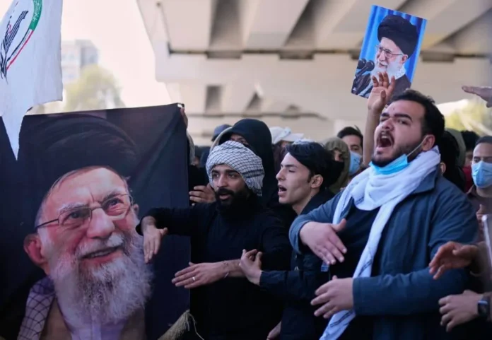 Warga Irak memegang potret pemimpin tertinggi Iran Ayatollah Ali Khamenei saat memprotes serangan AS dan Israel ke Iran