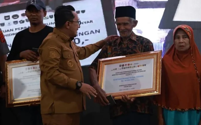 Bupati Tanahdatar Eka Putra menyerahkan secara simbolis bantuan perbaikan rumah rusak korban bencana
